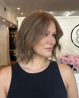 Woman with 12 inch medium brown bob styled with a wave.