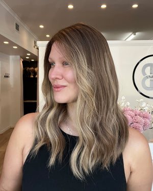 Woman with long, wavy hair in a salon setting