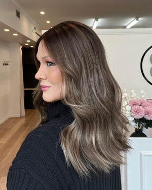 Woman with long hair looking at a mirror in a beauty salon.