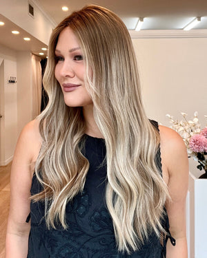 Woman with long, wavy blonde hair in a salon setting